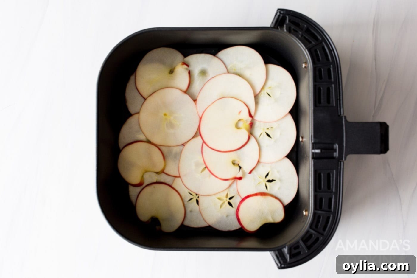apple slices in an air fryer basket