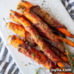 Sweet and Savory Air Fryer Bacon Wrapped Carrots 11 candied bacon wrapped carrots on a plate