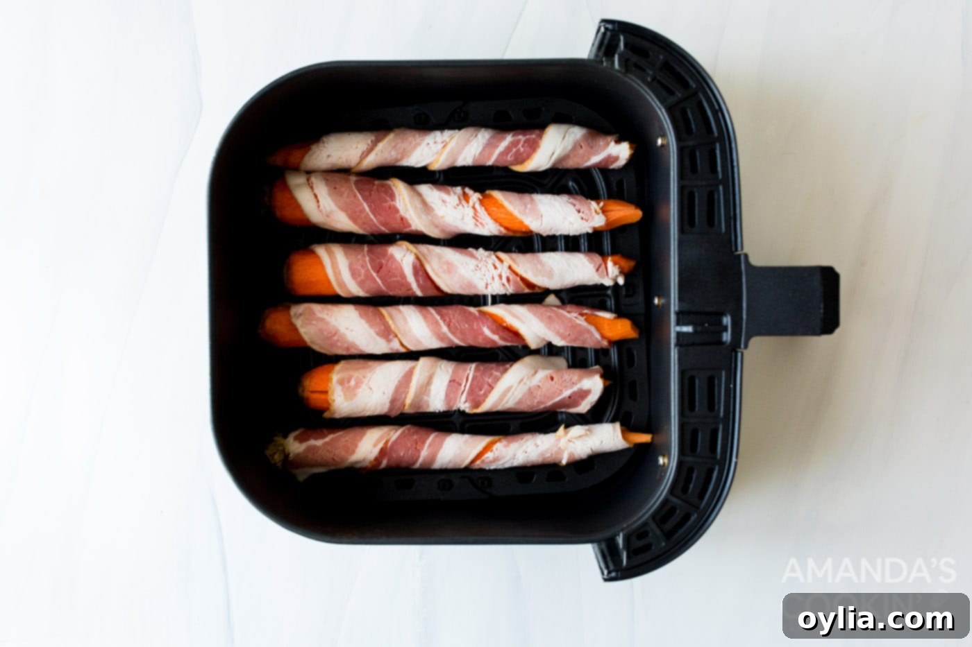 Sweet and Savory Air Fryer Bacon Wrapped Carrots 5 bacon wrapped carrots in an air fryer