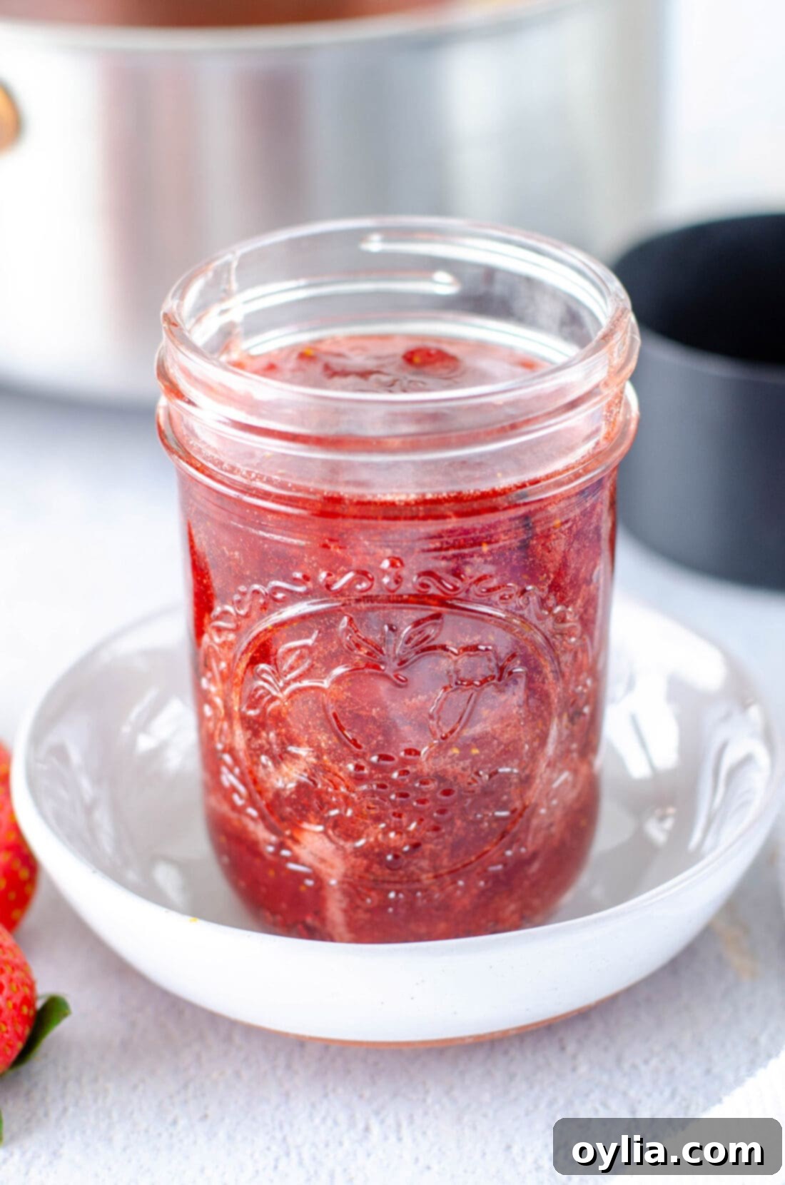 close-up of a jar of strawberry jam, highlighting its texture.