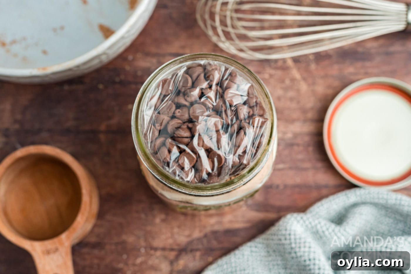 Bagged chocolate chips placed on top of mug cake mix in a jar.