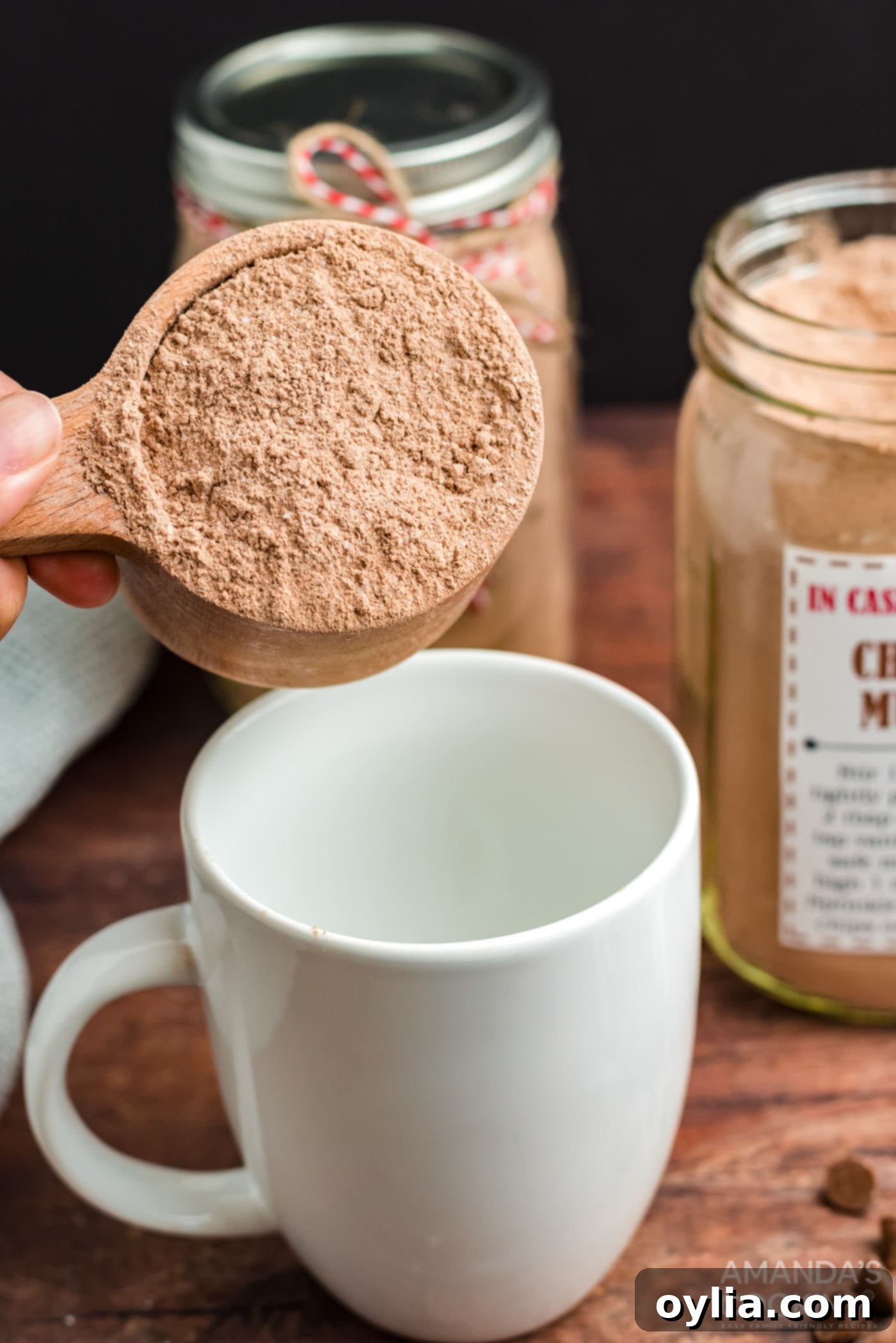 Scooping cake mix from the jar into a mug.