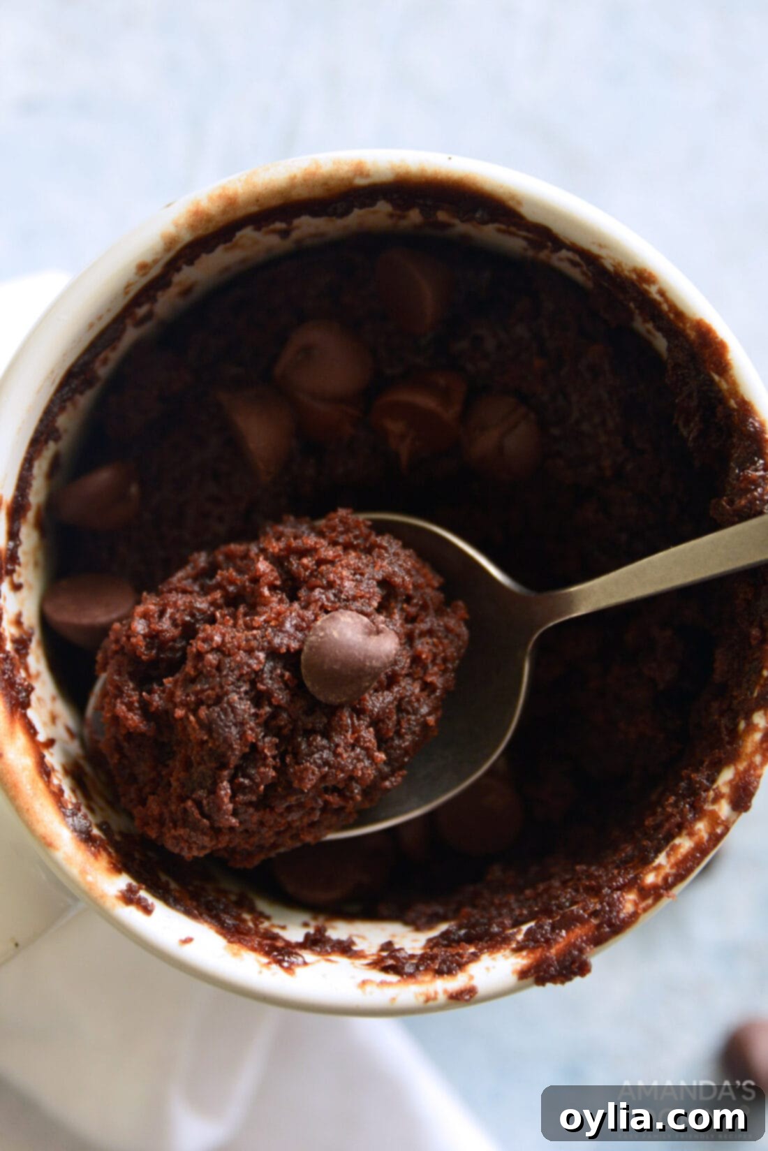 Overhead view of a delicious chocolate mug cake with melted chocolate chips.
