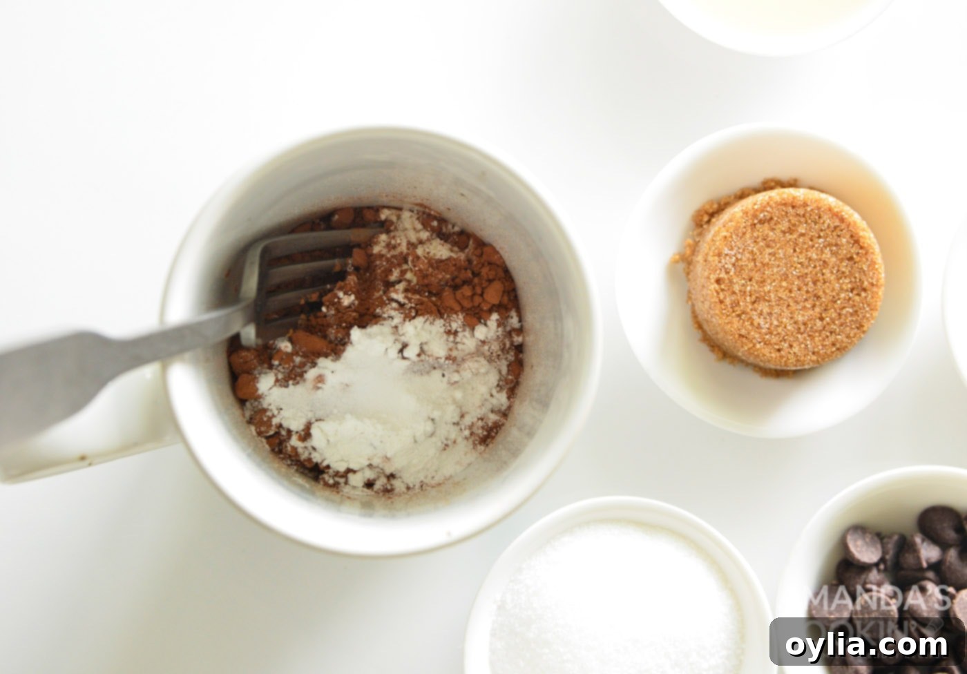 Dry ingredients like flour, cocoa, and sugar mixed in a mug.