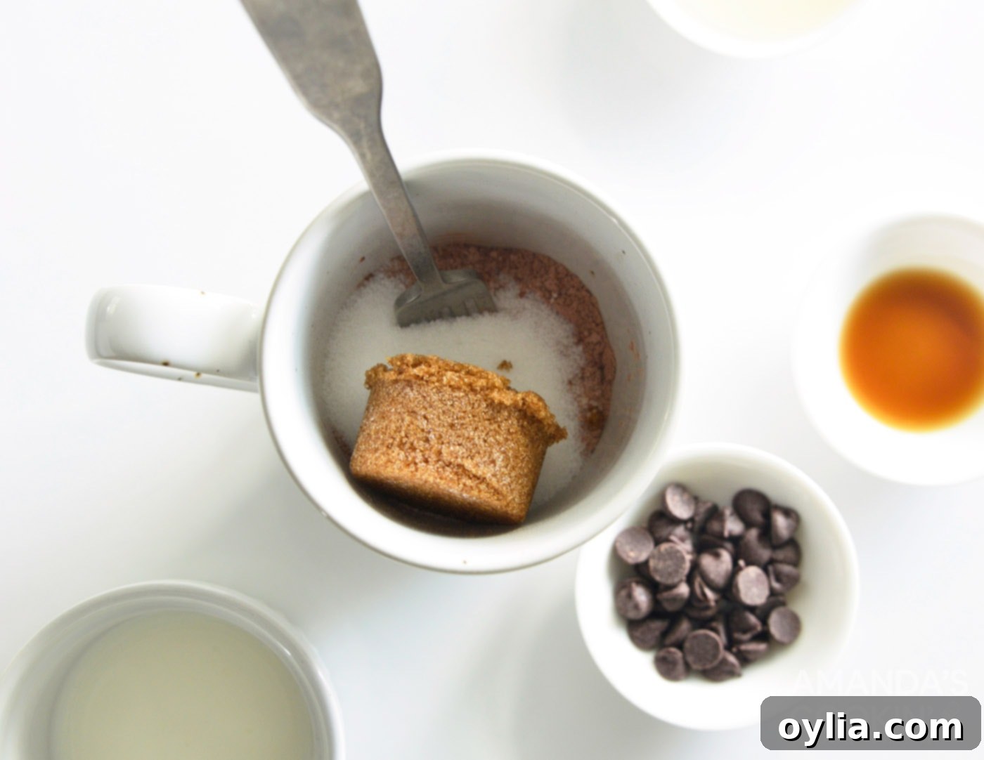 Brown sugar added to the dry ingredients in a mug.