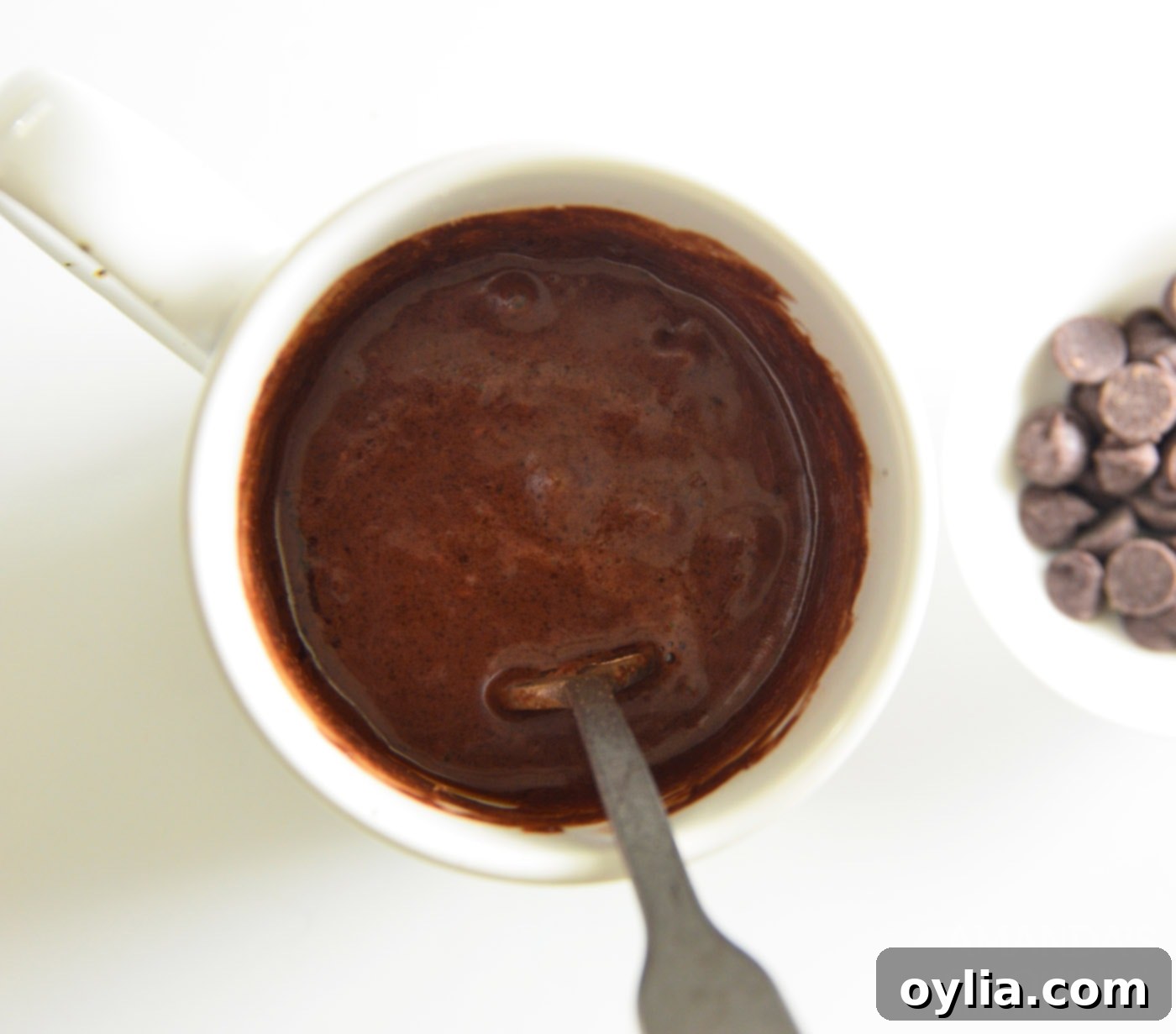 Cake batter mixed in a mug, smooth and ready for microwave.