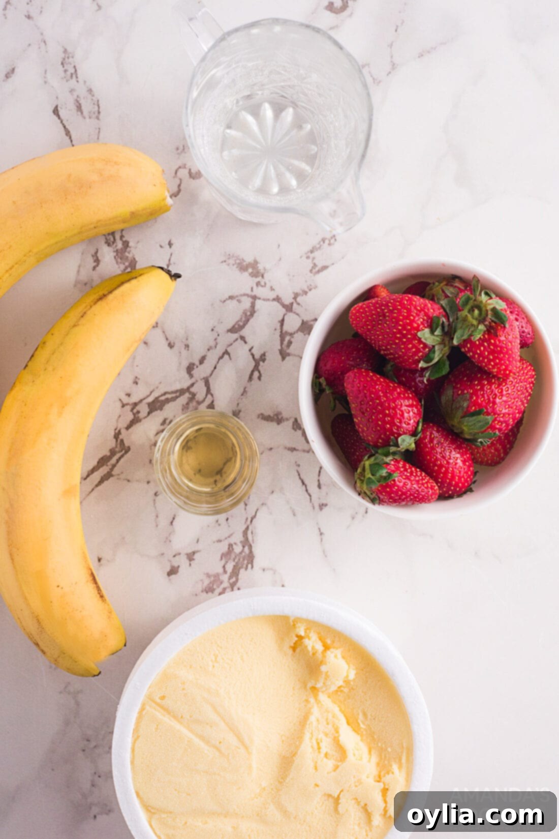 Collection of fresh ingredients for strawberry banana floats: strawberries, bananas, vanilla ice cream, club soda, simple syrup