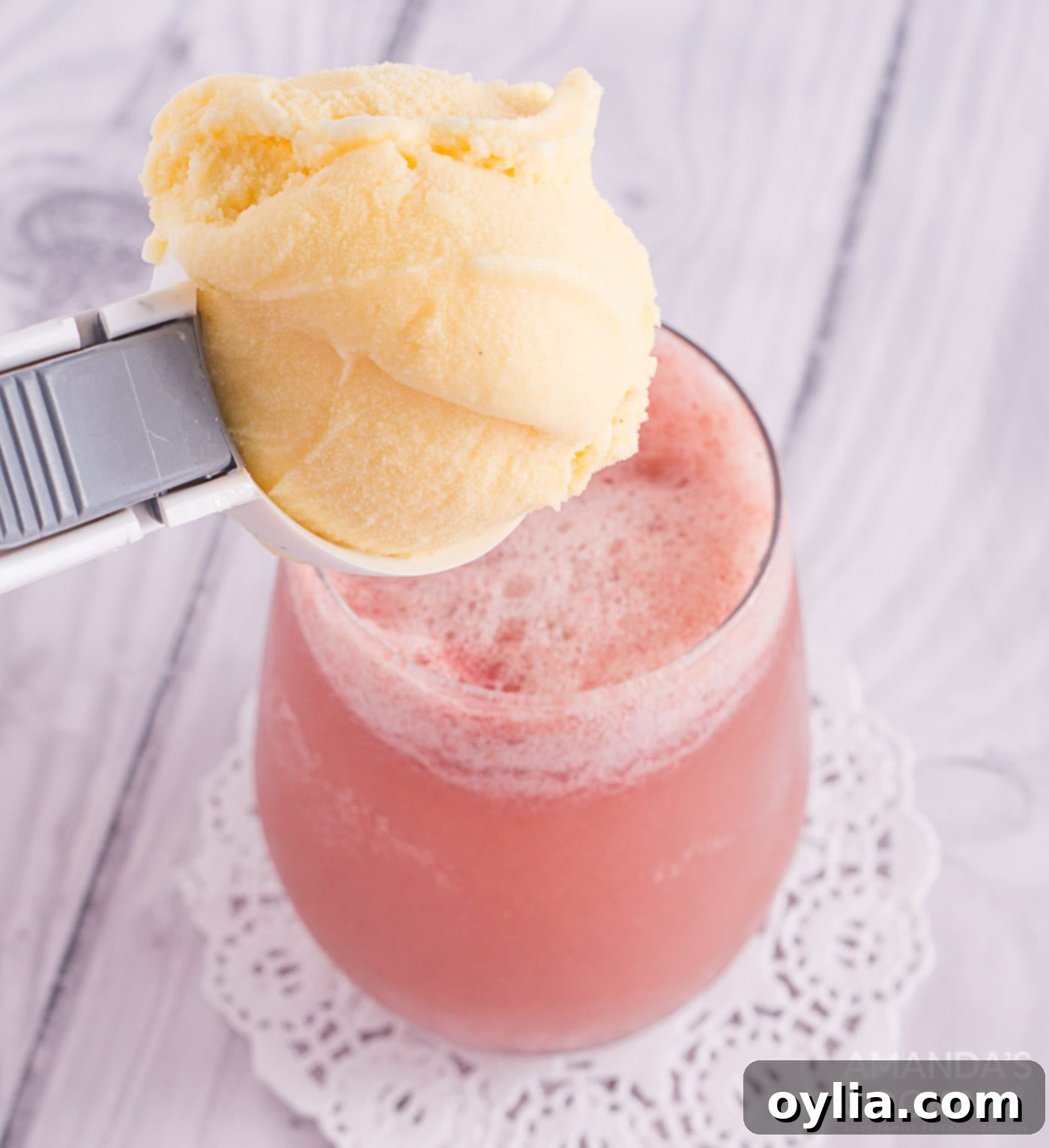 scoop of vanilla ice cream over strawberry banana float, ready to be served