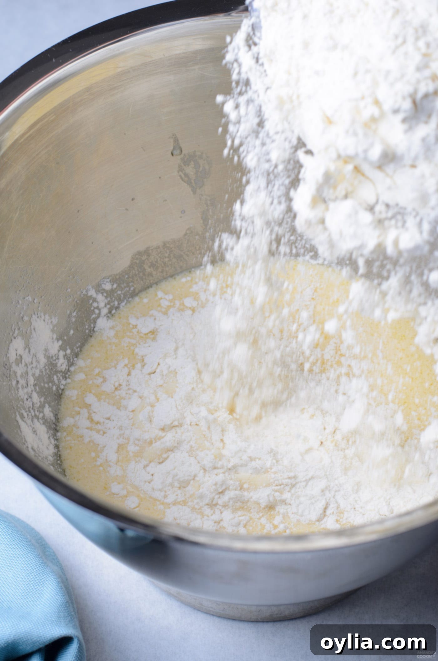 pouring flour into yeast mixture