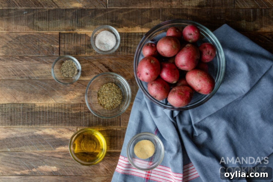 A flat lay image displaying the ingredients needed for air fryer roasted potatoes: various potatoes, olive oil, and a selection of dried herbs and spices.