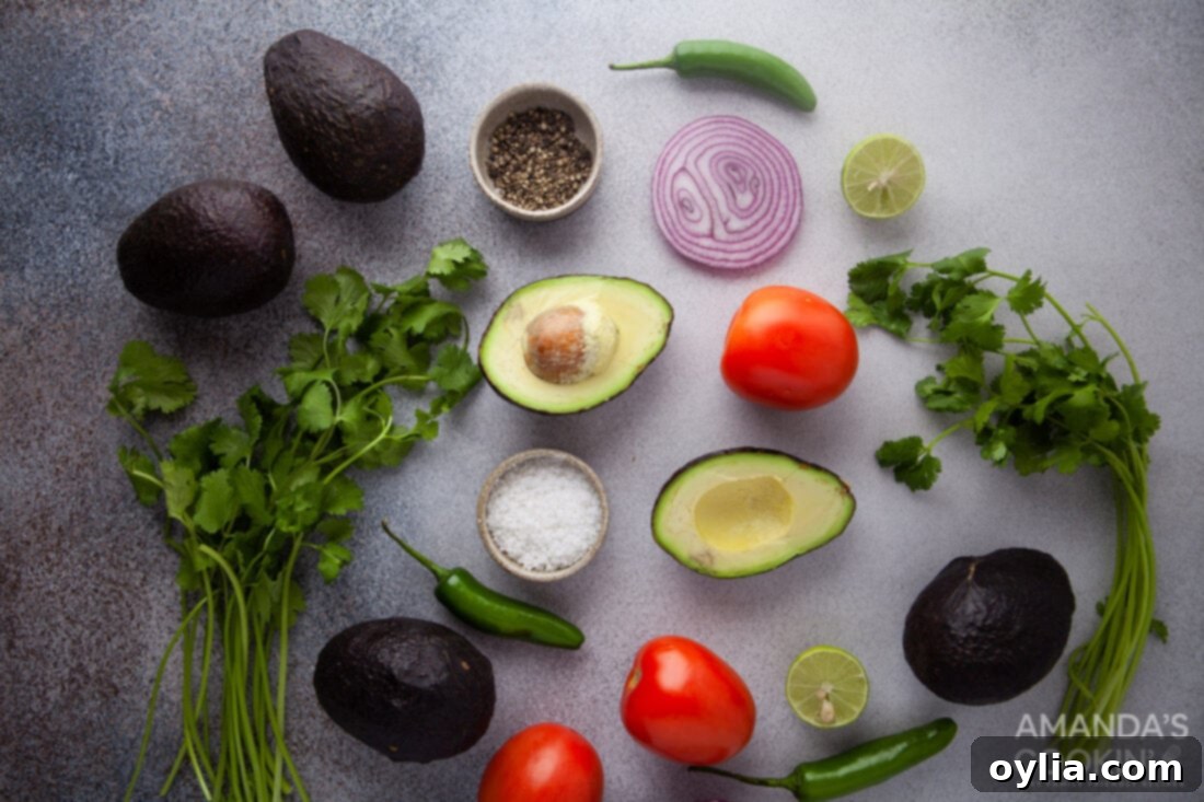 Homemade Guacamole 4 Fresh ingredients laid out for making guacamole: avocados, lime, red onion, serrano pepper, tomato, cilantro
