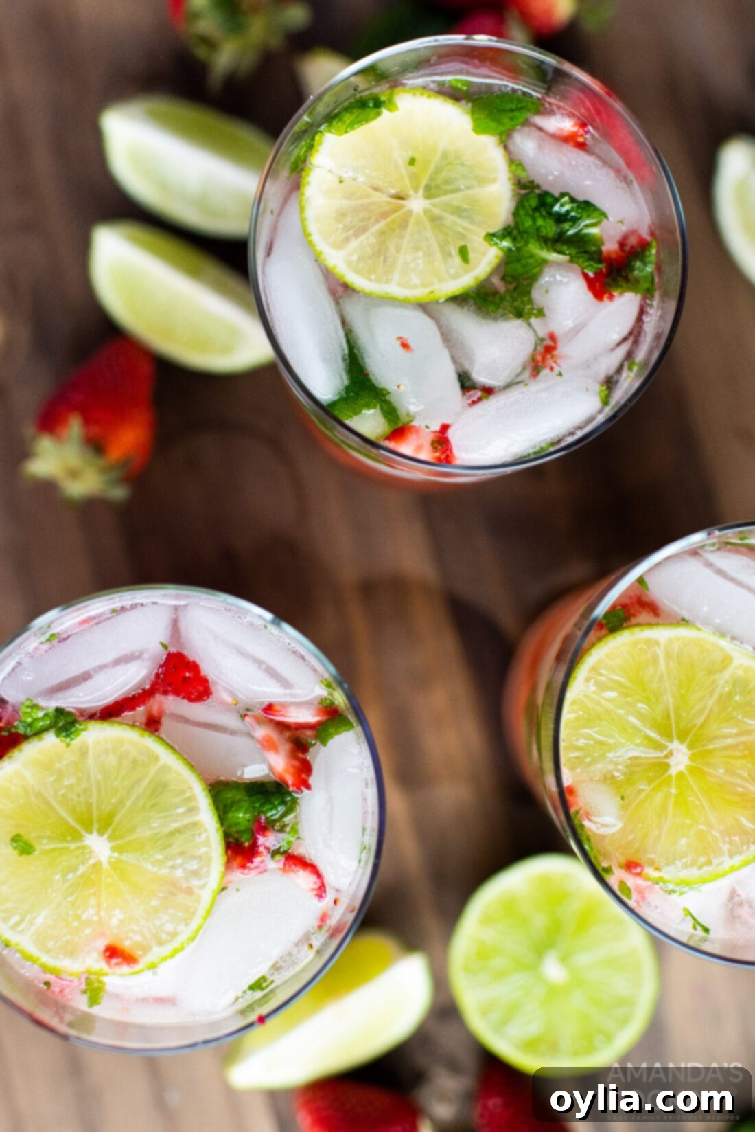 Overhead shot of two beautifully crafted Strawberry Mojitos, garnished with lime and mint.