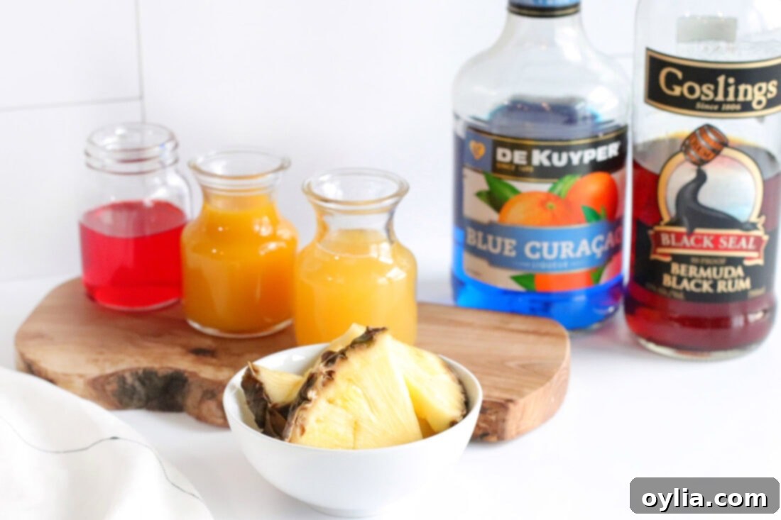 Ingredients for Blue Hawaiian Mai Tai laid out on a table: dark rum, blue curaçao, mango juice, pineapple juice, grenadine, ice, and garnishes