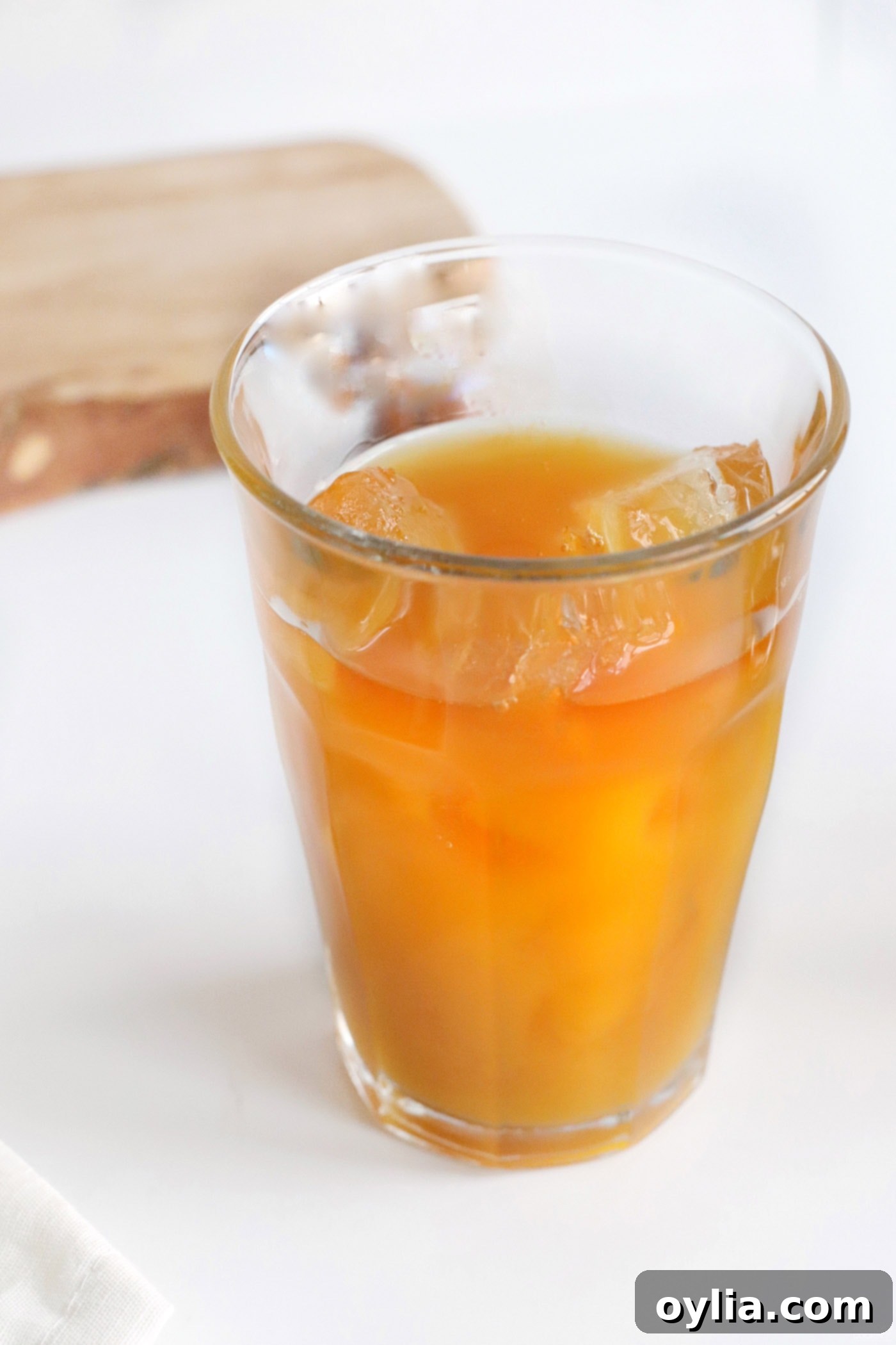 Pineapple juice mixed with mango juice and rum in a glass with ice