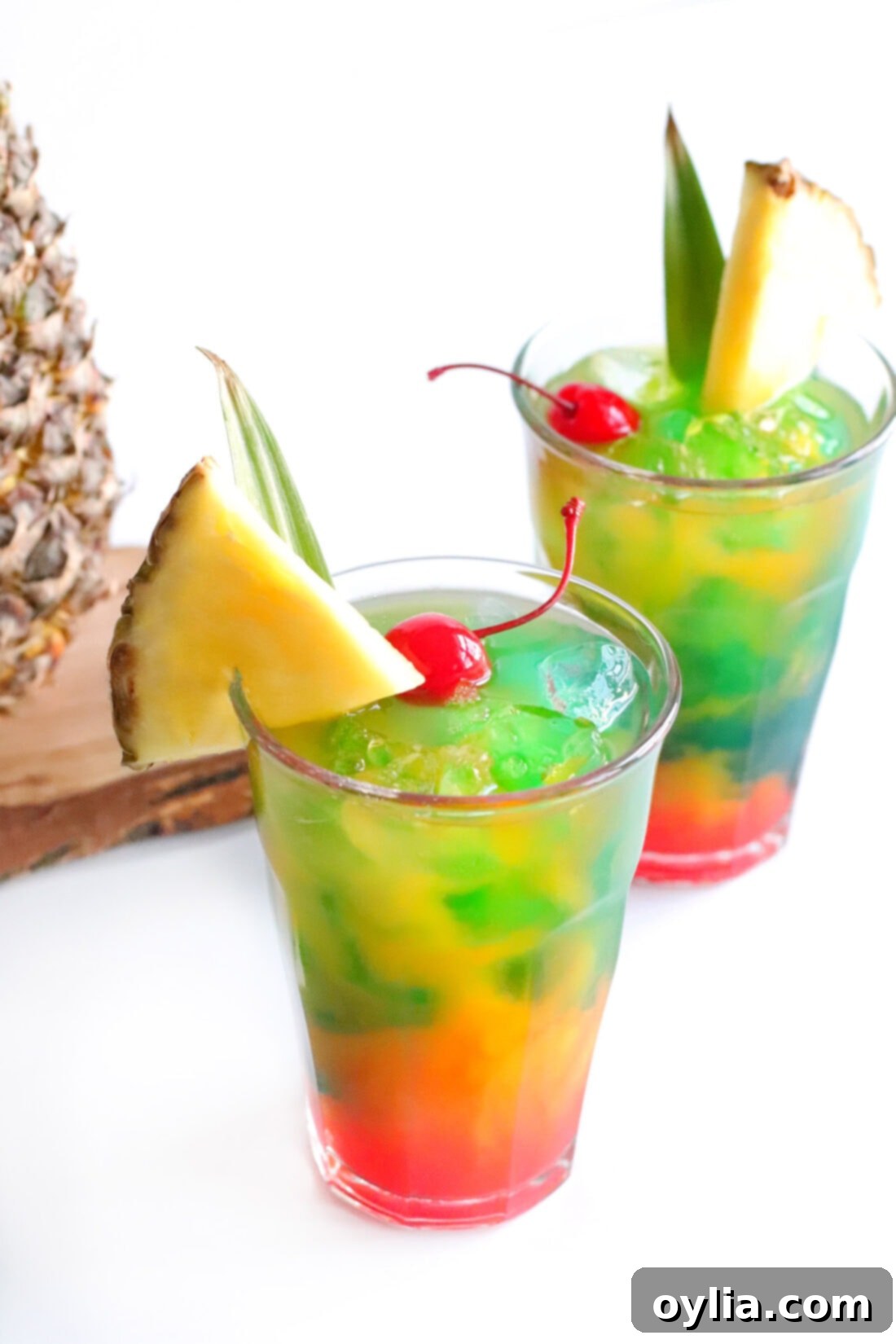 Two Blue Hawaiian Mai Tai drinks garnished with a pineapple wedge and cherry, ready for serving