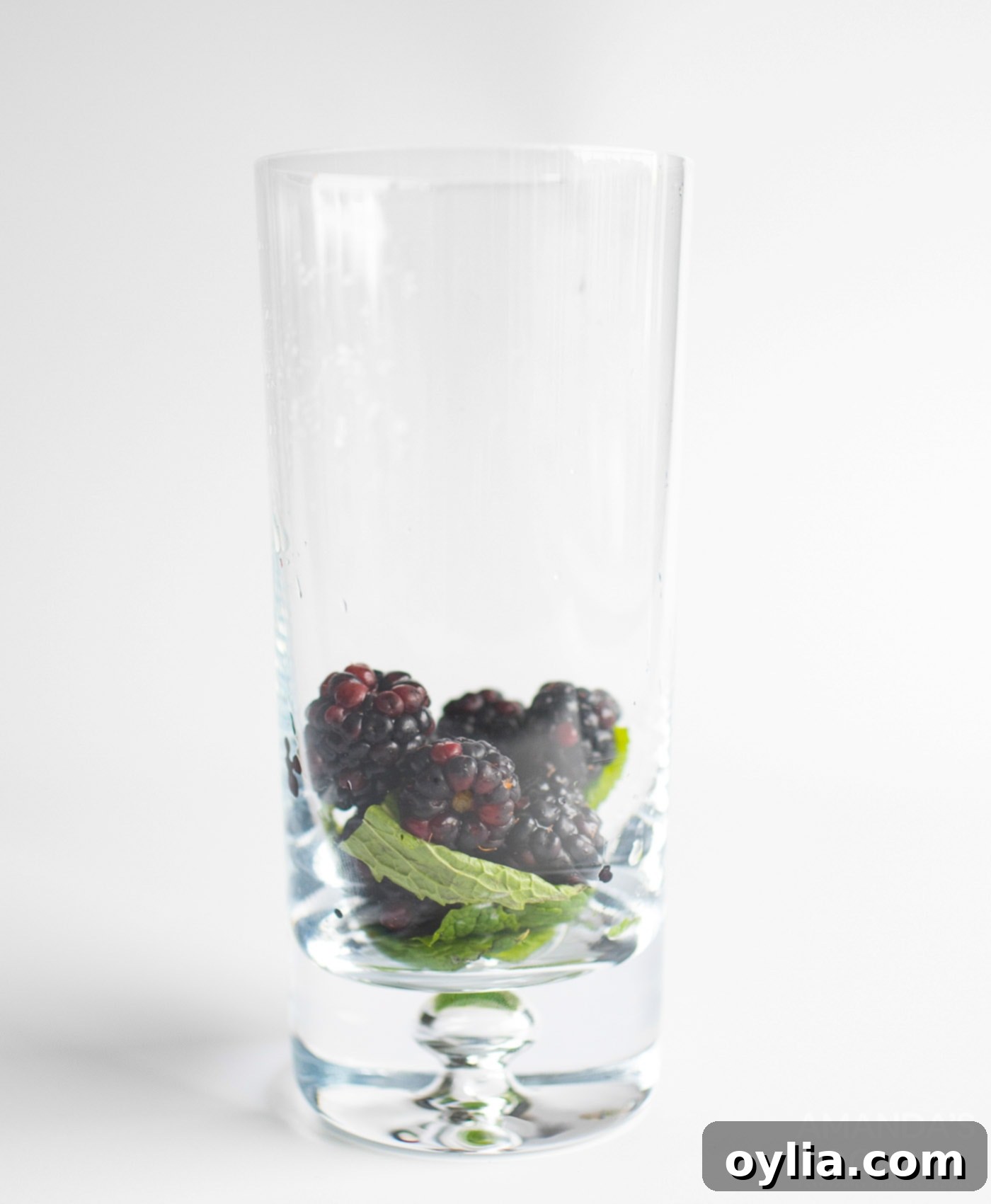 blackberries and mint leaves in a tall glass