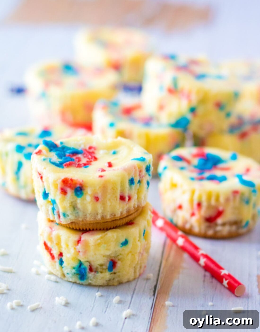An appetizing display of stacked Patriotic Mini Cheesecakes, with more arranged decoratively in the background, set for a holiday gathering.
