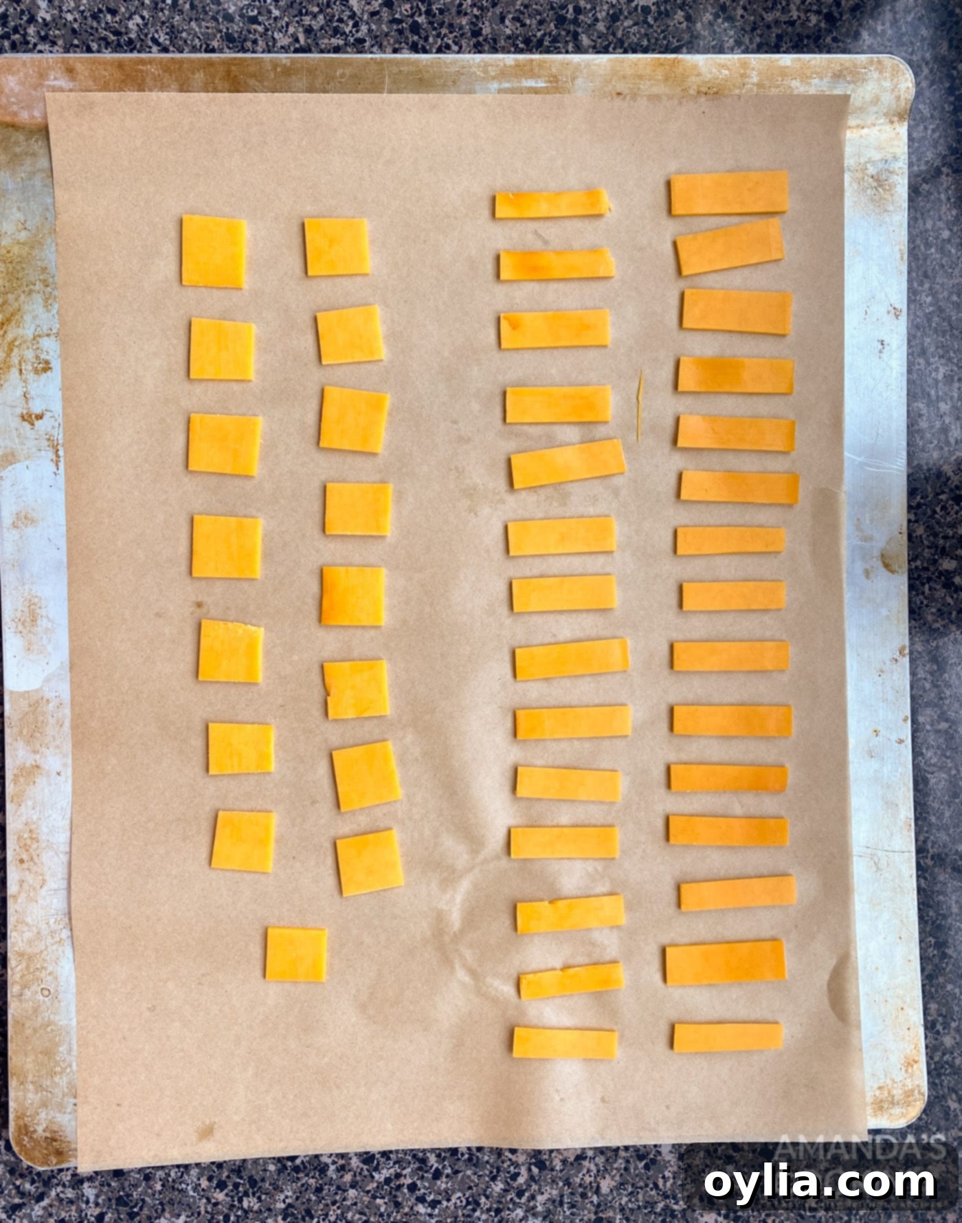 precisely cut small cheese squares arranged on parchment paper