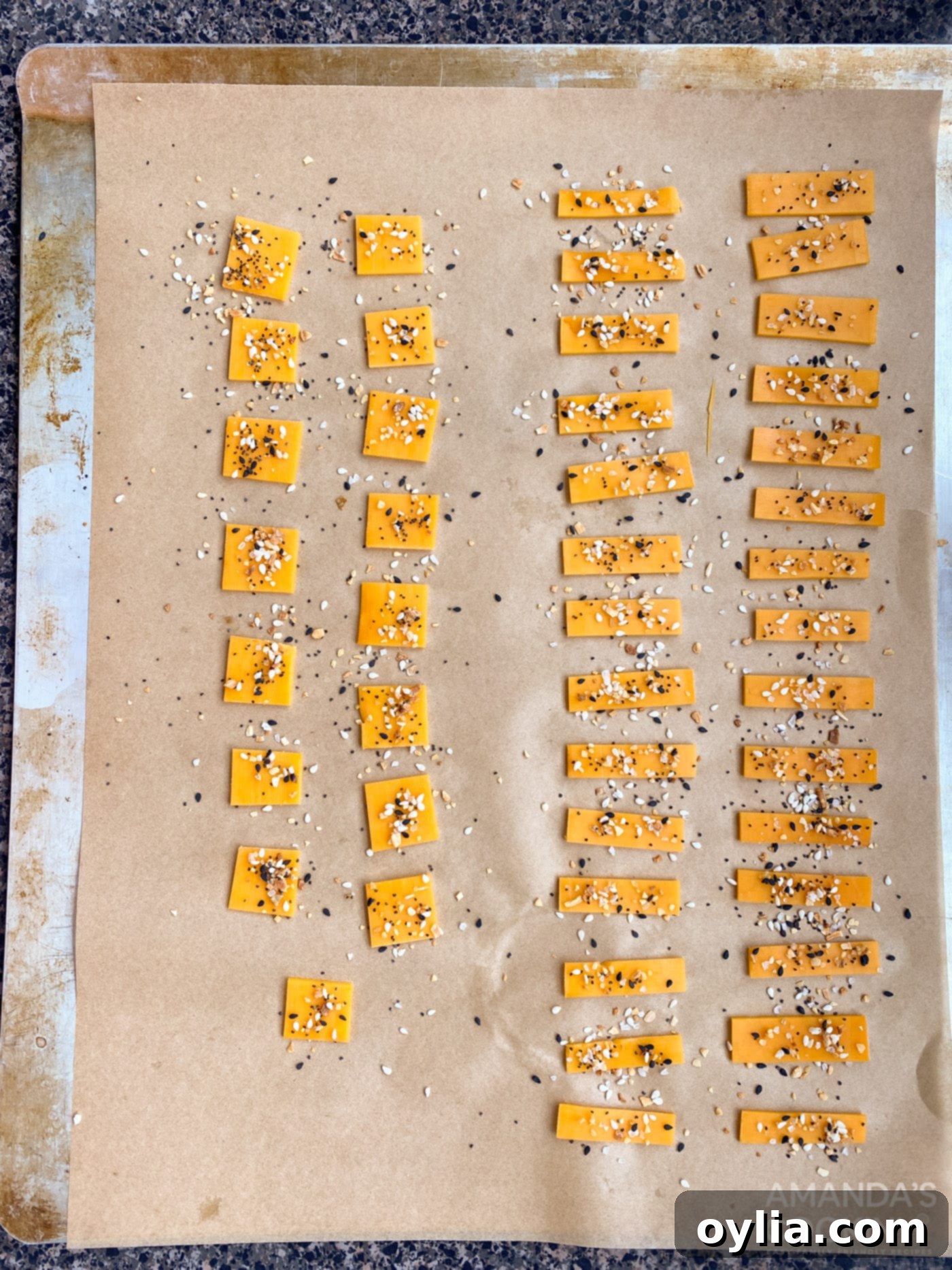 cheese pieces seasoned with Everything Bagel Seasoning on a baking sheet