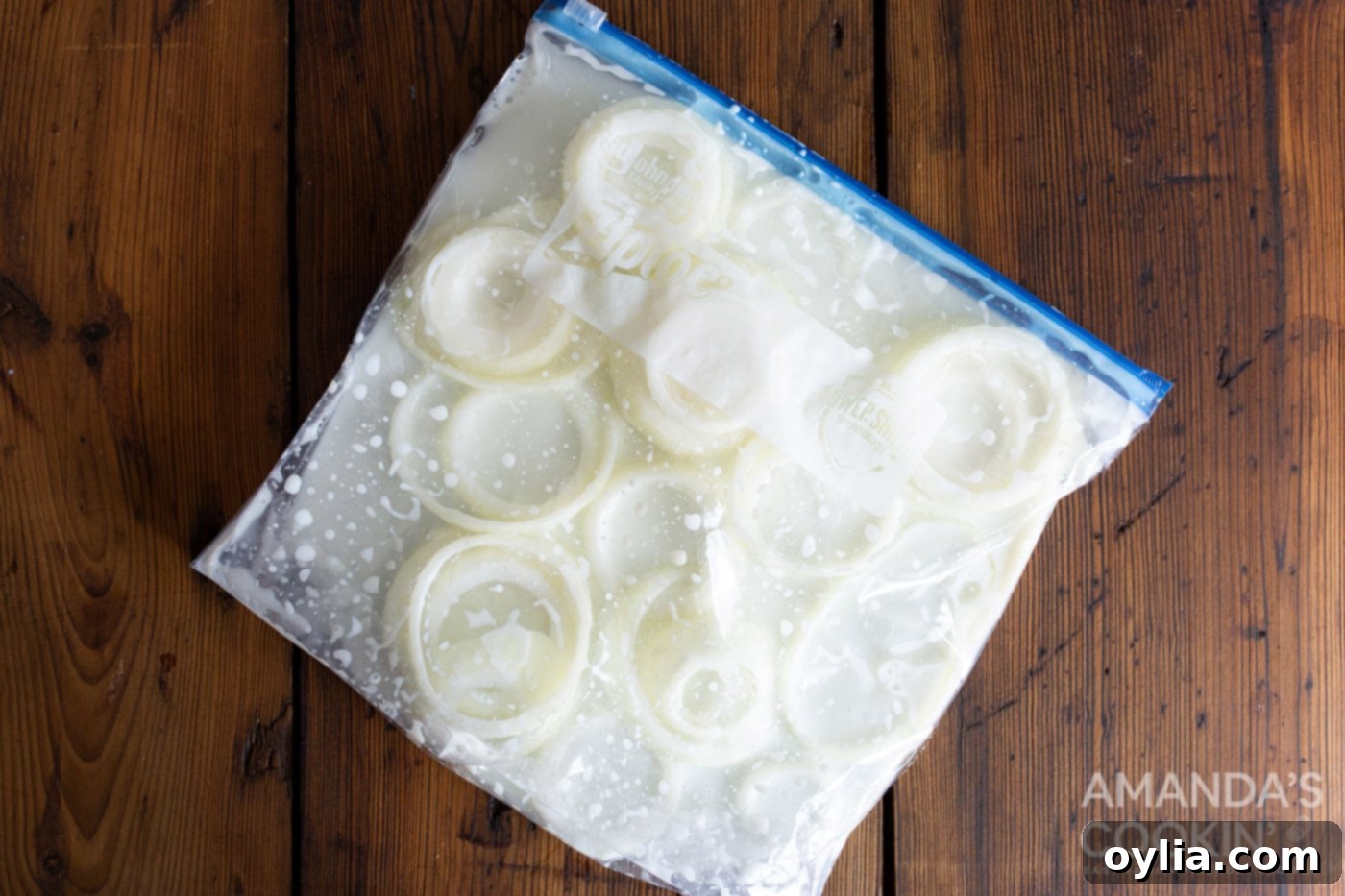 Sliced onion rings soaking in a bag of buttermilk