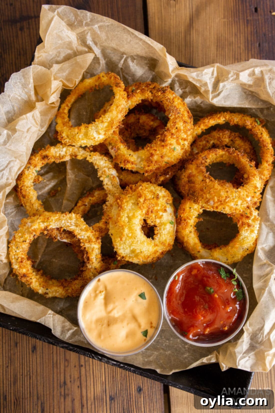 Freshly air fried onion rings served on a tray with parchment paper