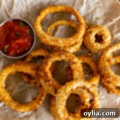 Air Fryer Onion Rings on parchment with dish of ketchup