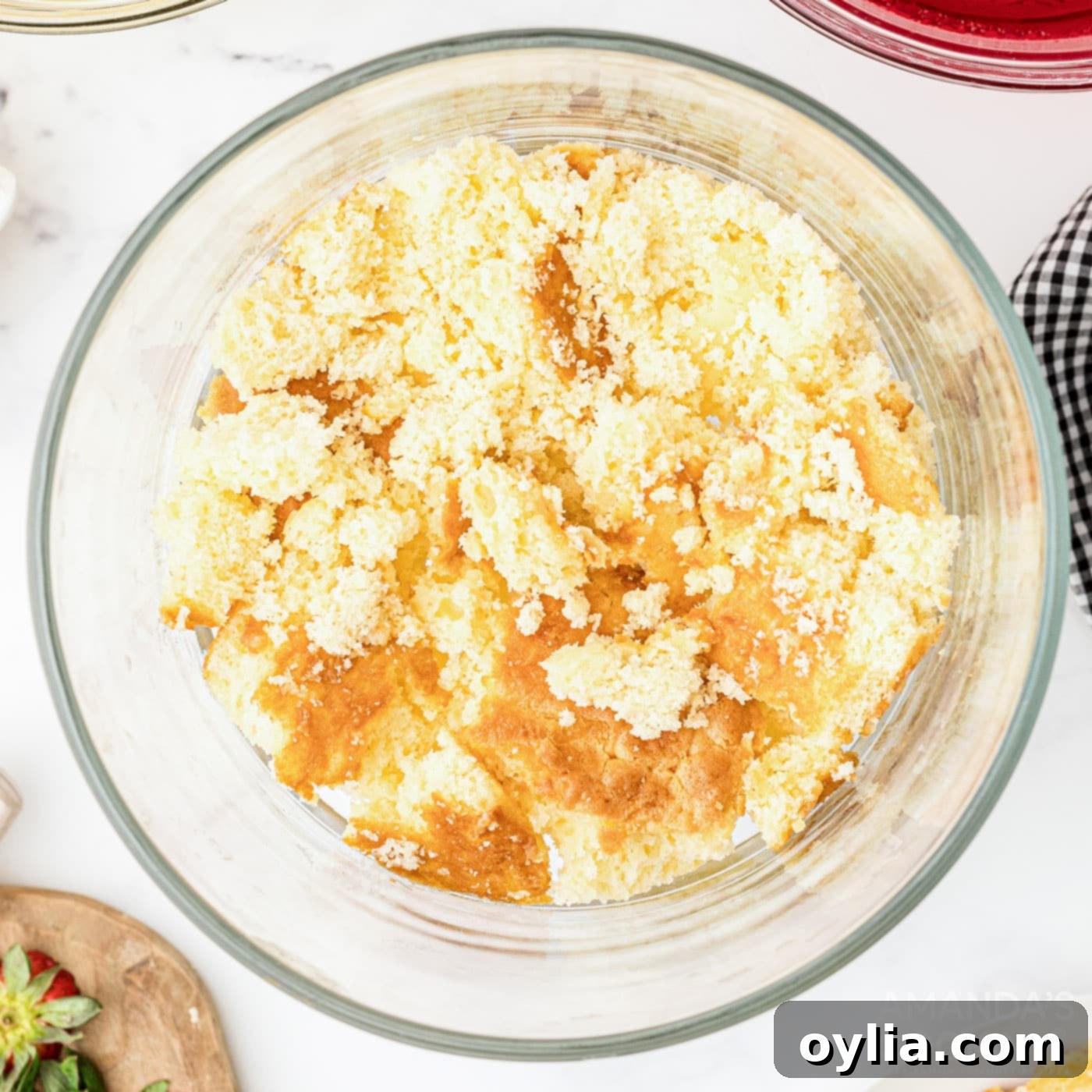 crumbled cake on the bottom of trifle dish, establishing the first layer