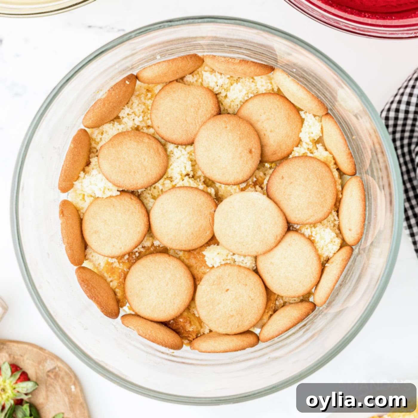 vanilla wafers on top of cake in trifle bowl, ready for the next layer
