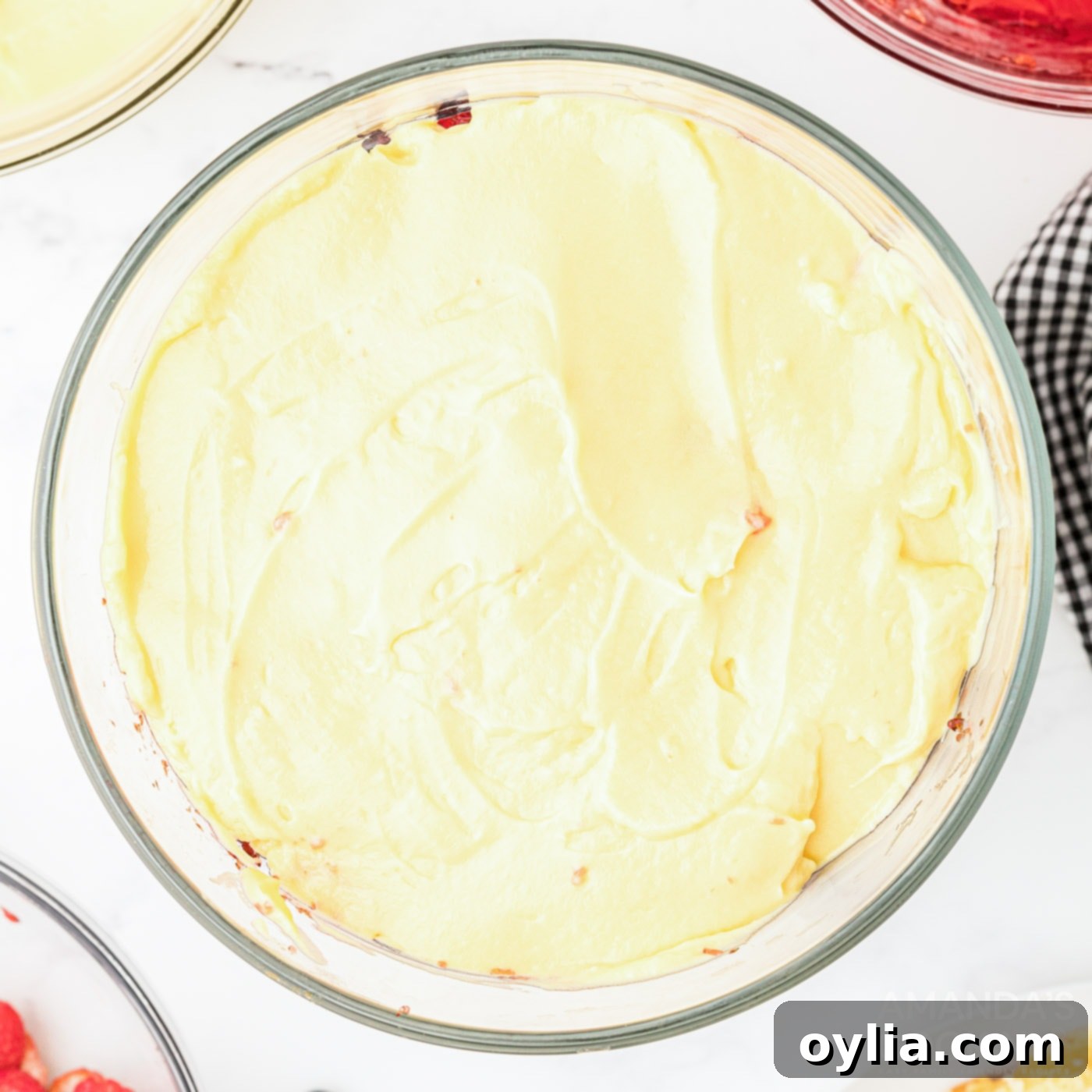 layer of vanilla pudding in trifle bowl, completing the first round of layers