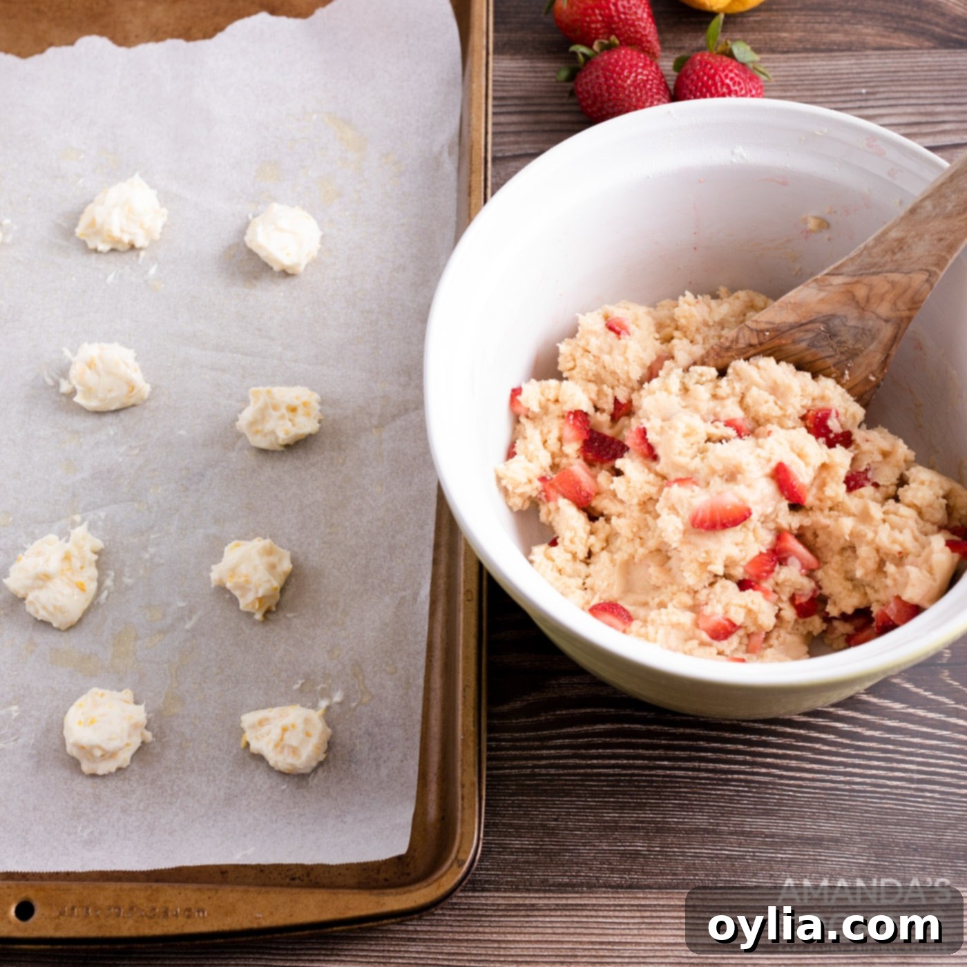 cream cheese balls on baking sheet next to bowl of strawberry cookie dough