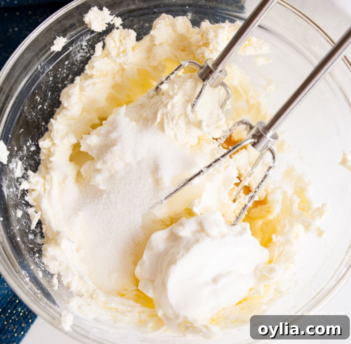 beating cheesecake ingredients with a hand mixer