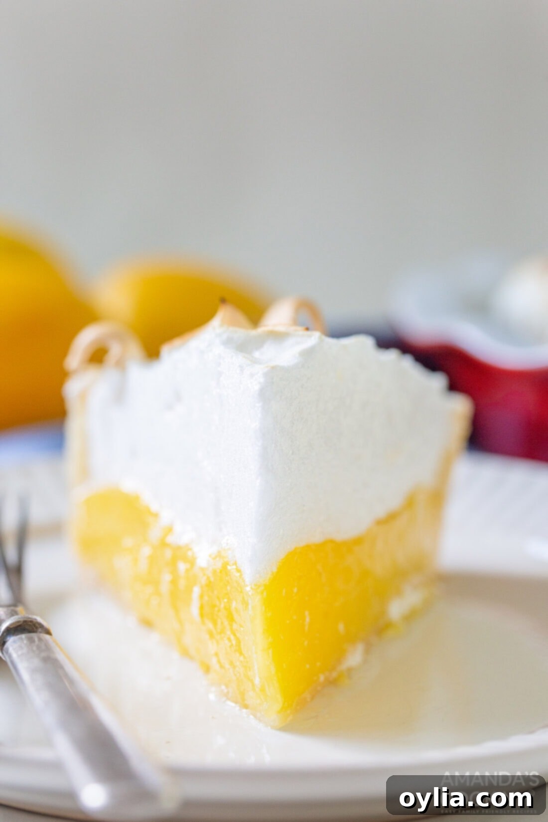 slice of lemon meringue pie with a fork taking a bite