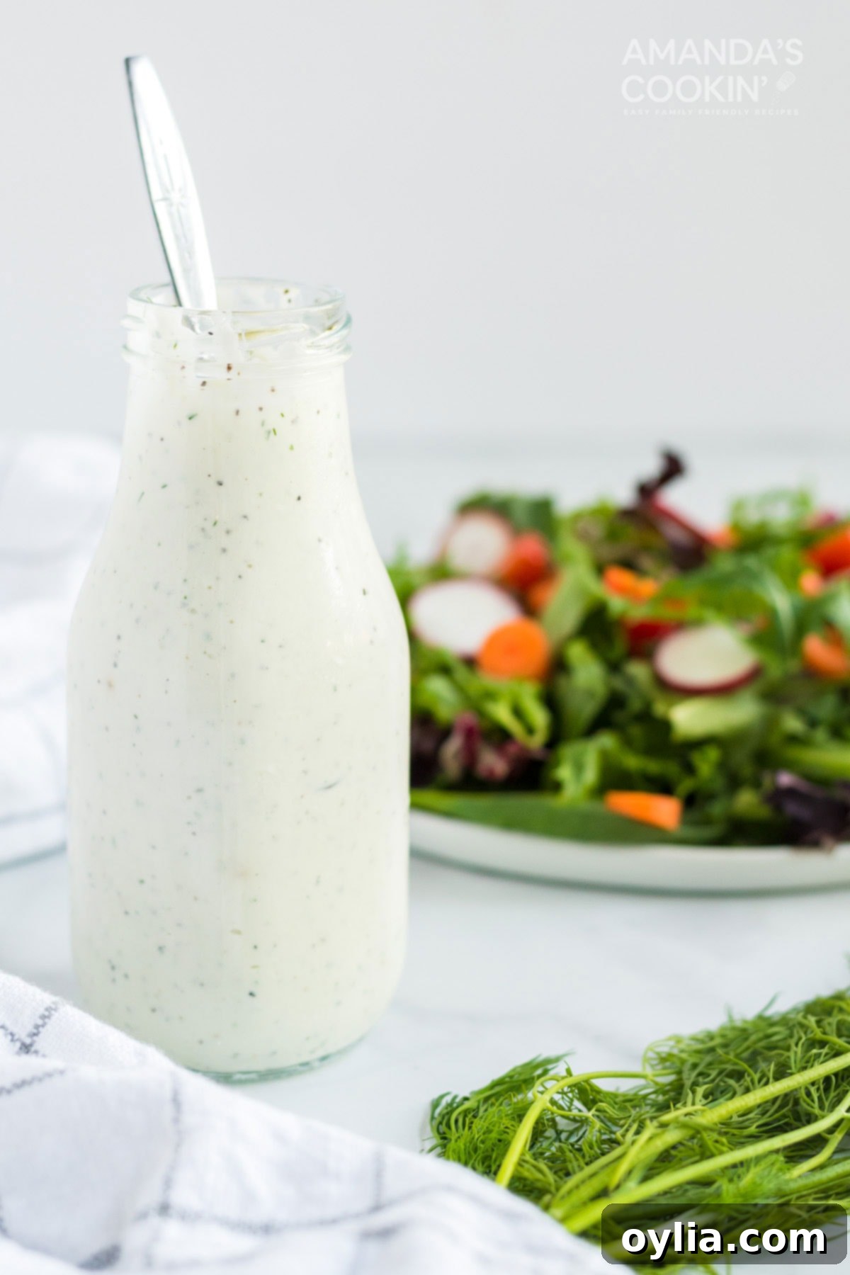2 minutes and 7 ingredients is all it takes to make a delicious homemade dill dressing that also doubles as a vegetable dip! bottle of dill dressing with a spoon and salad