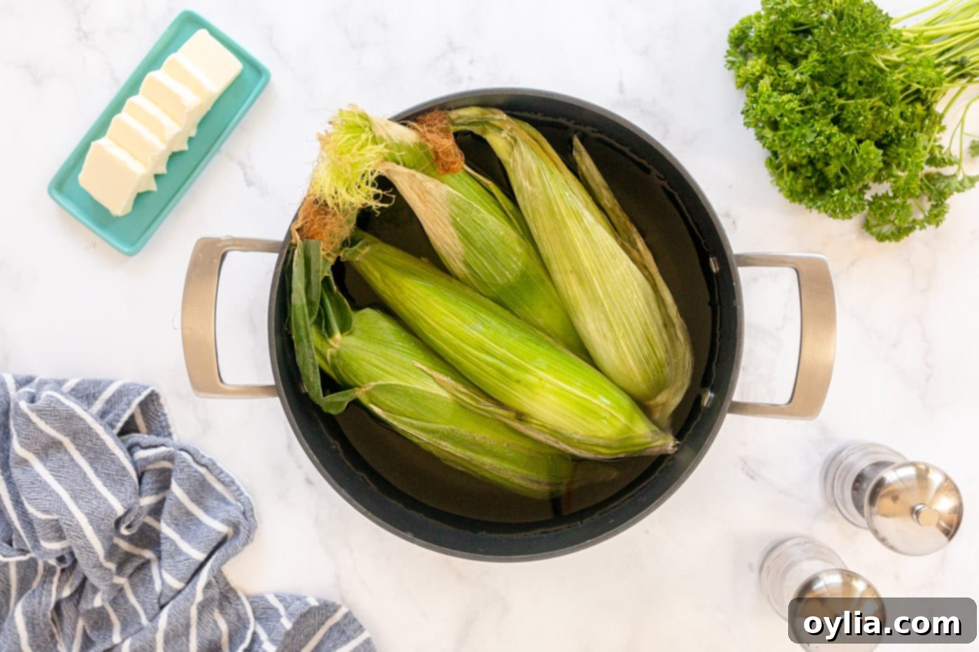 corn on the cob soaking in a pot of water