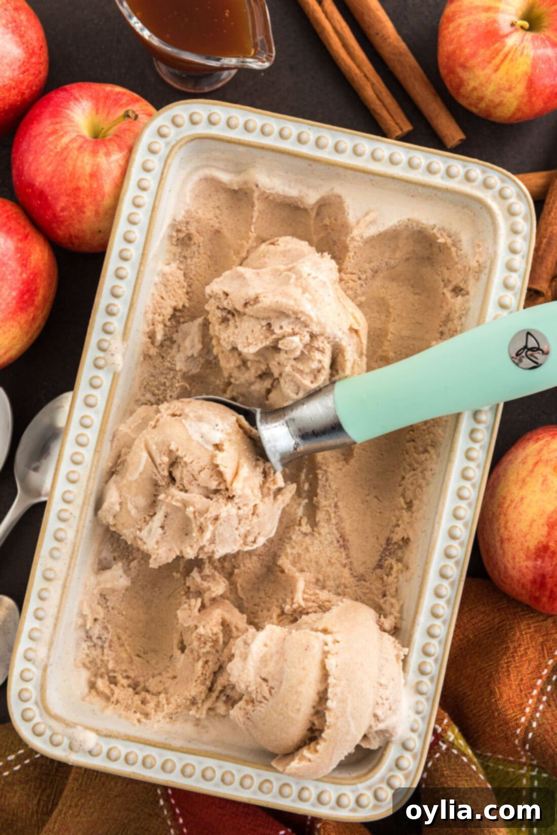 Pan of Apple Cider Ice Cream with an ice cream scoop, ready to be served.
