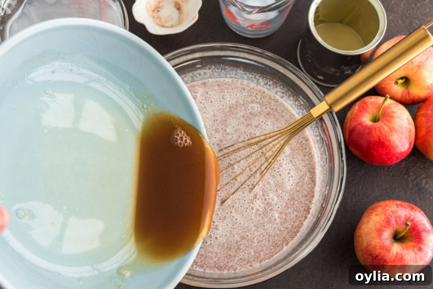 Pouring the cooled, reduced apple cider into the prepared cinnamon and cream mixture, ensuring even distribution.