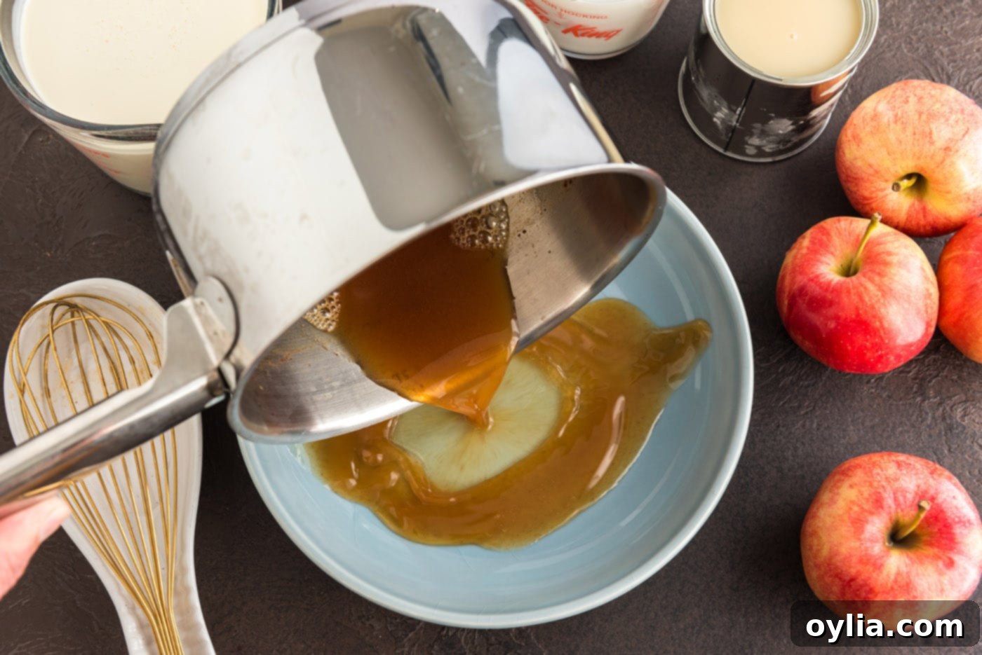 Pouring the reduced apple cider onto a large plate to facilitate rapid cooling.