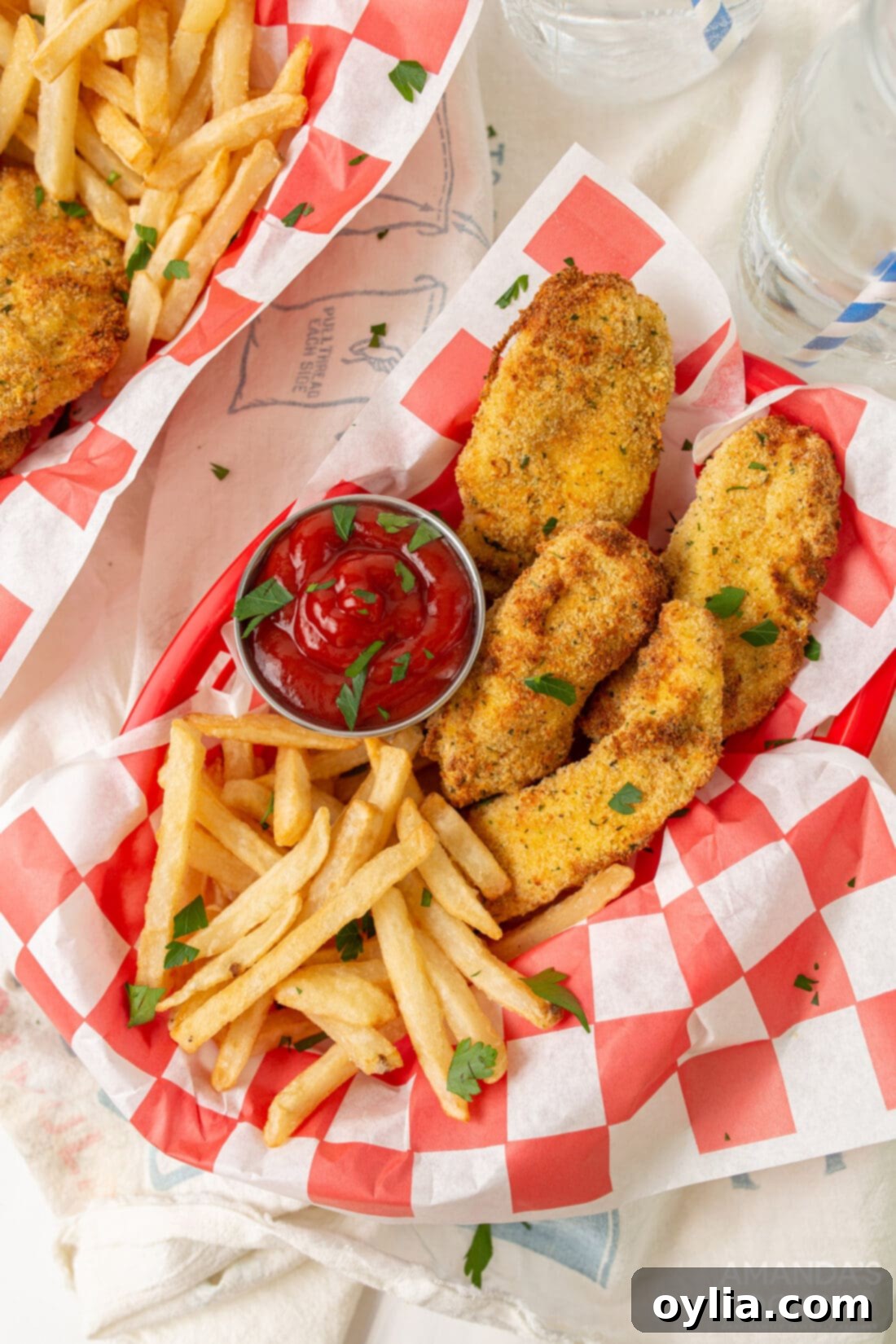 Quick and Crispy Air Fryer Chicken Tenders 2 air fryer chicken tenders in baskets with fries