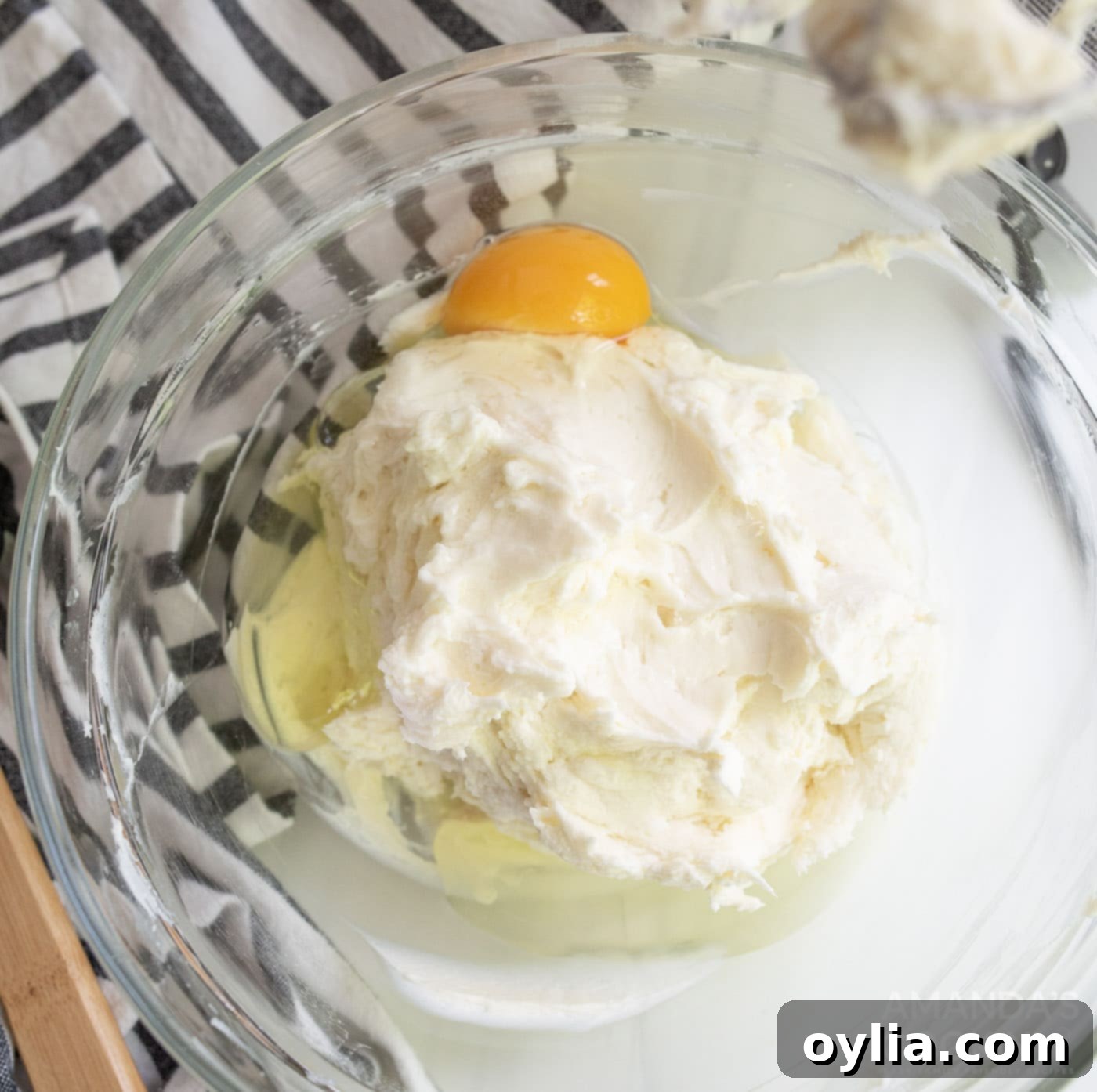 lemon juice, vanilla extract, and an egg in bowl with cream cheese mixture