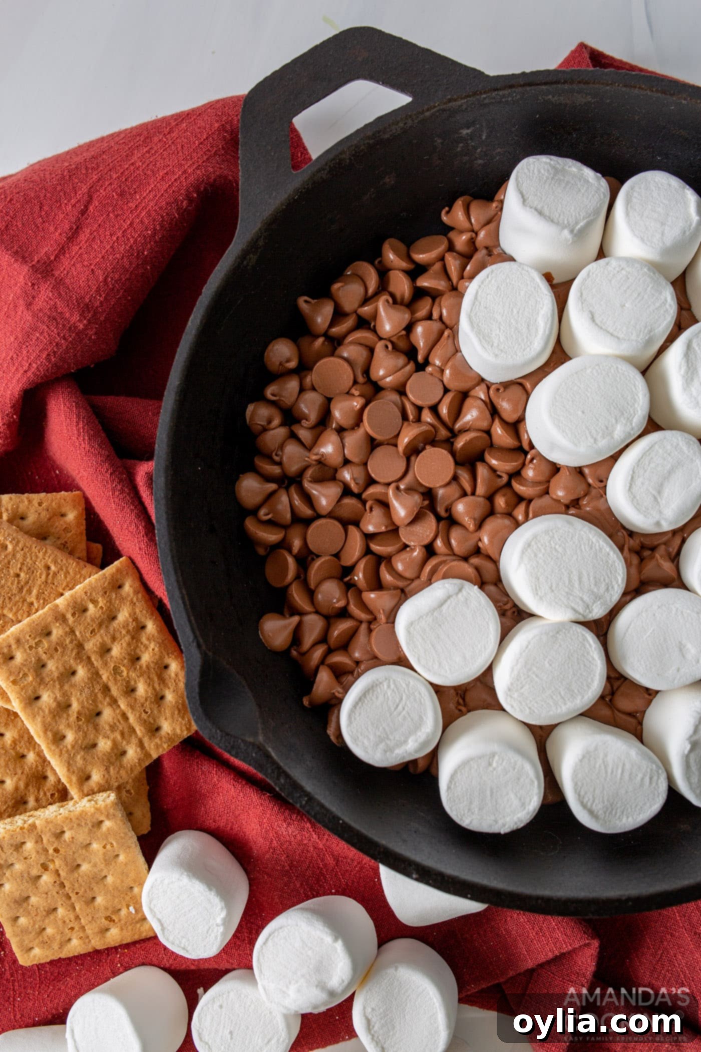 marshmallows on top of chocolate chips in a skillet