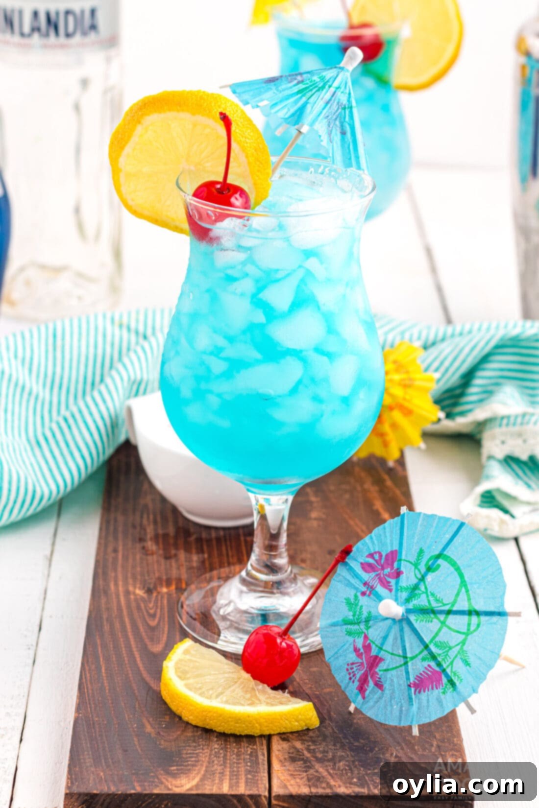 Blue Lagoon Cocktail - A stunning blue drink garnished with a lemon slice and a cherry.