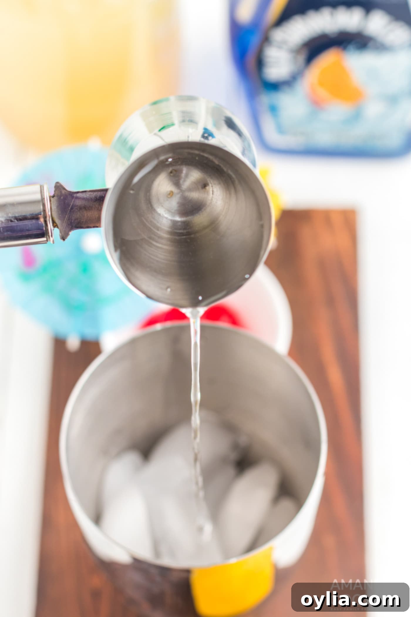 pouring vodka into cocktail shaker with ice