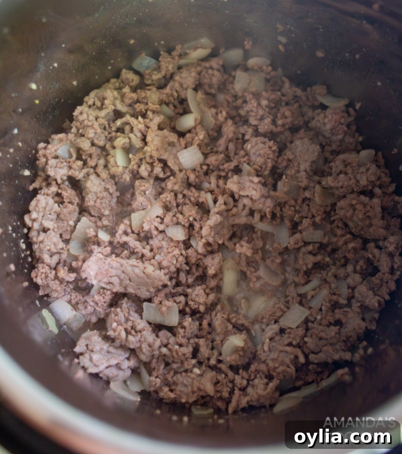 pork, beef, and onions sauteeing in the instant pot