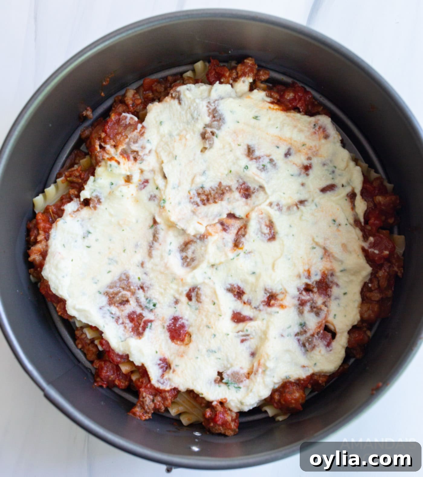 ricotta mixture on top of lasagna noodles in a pan