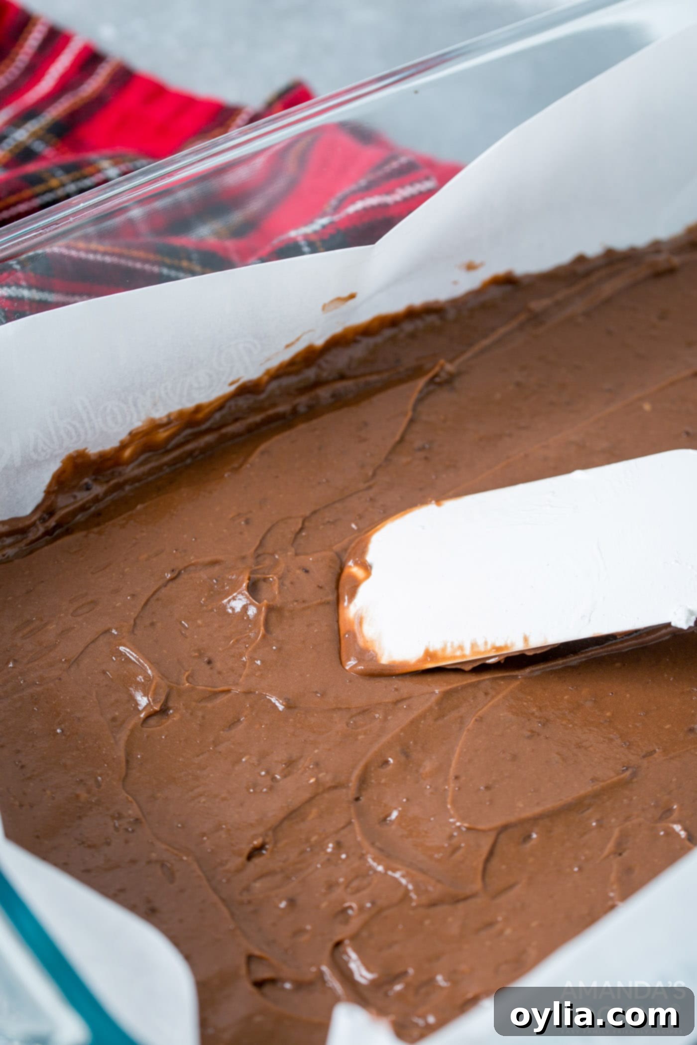 rubber spatula smoothing chocolate pudding into pan