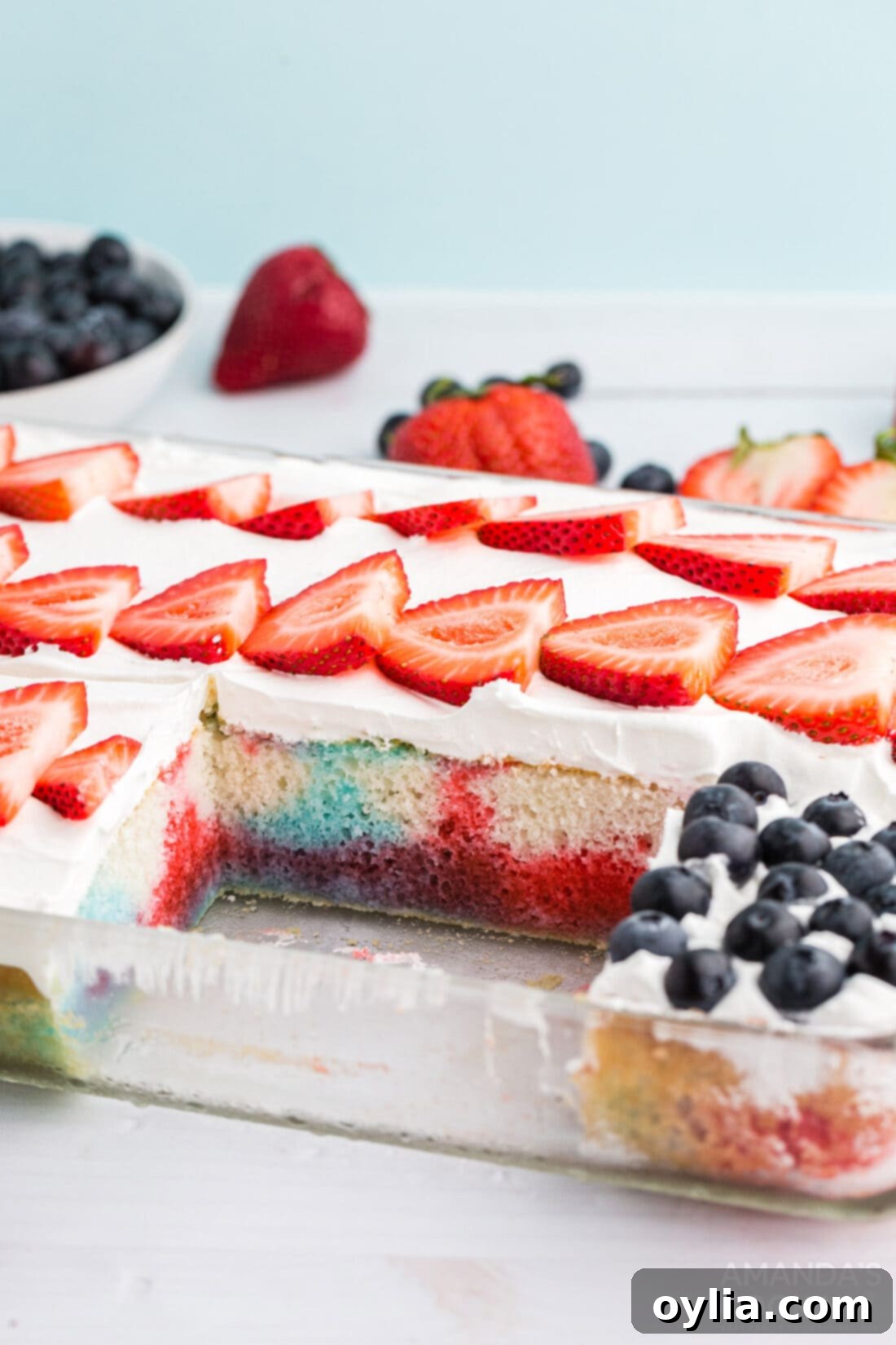 US flag poke cake with a slice removed, showing moist red and blue interior