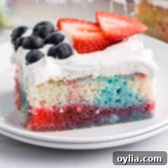 Red White and Blue Poke Cake on a white plate with a slice removed