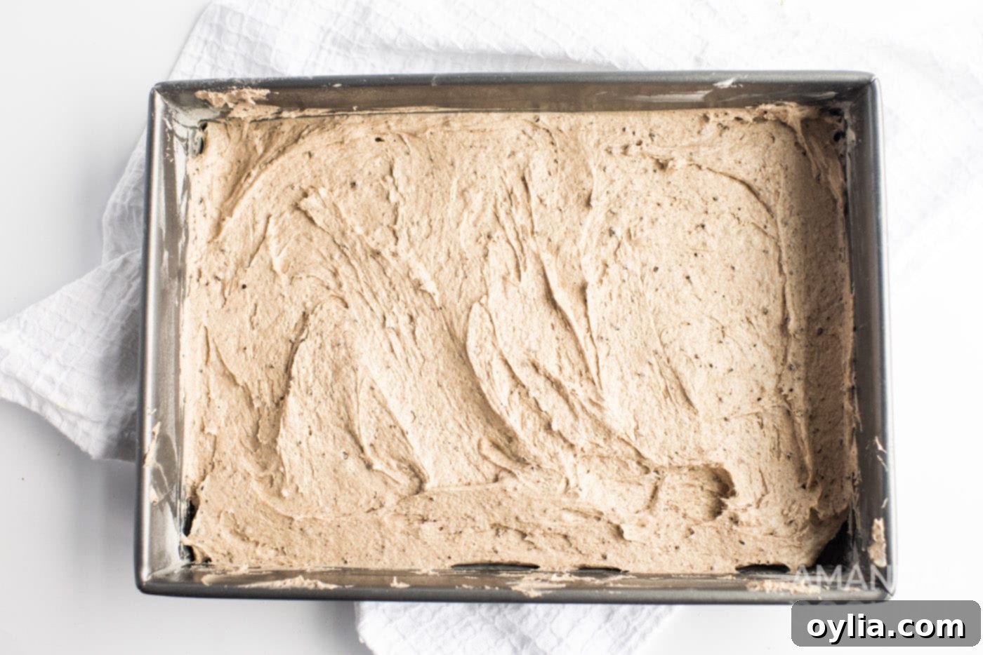 Oreo cake batter spread evenly in a 9x13 baking pan, ready for the oven.