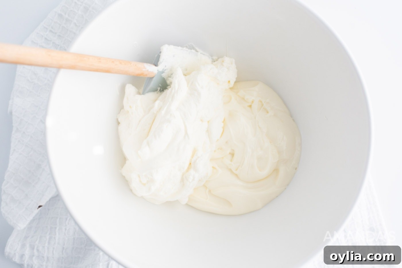 Creamy cheesecake and fluffy whipped topping mixture in a mixing bowl, ready for assembly.