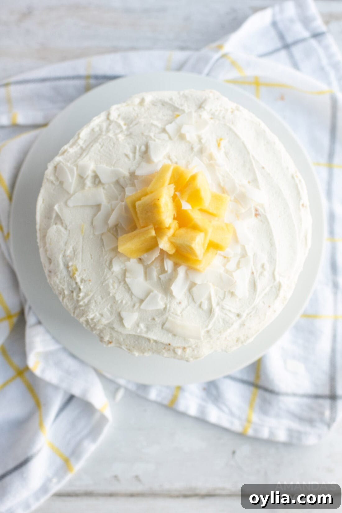 Overhead view of a beautifully frosted Pineapple Cake, ready to be served, highlighting its tropical appeal.